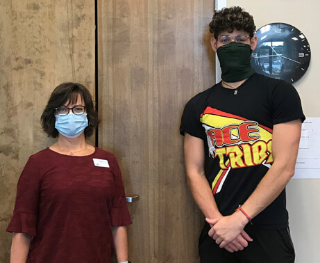 Jack standing next to his therapist, both wearing masks.
